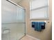 Bathroom featuring a glass enclosed shower, neutral tones, and a white window at 10942 High Bush Ct, Orlando, FL 32825