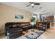 Open-concept space with a leather sofa, tile flooring, and a clear view of the kitchen at 10942 High Bush Ct, Orlando, FL 32825