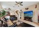 Spacious living room showcasing a leather sofa, ceiling fan, mounted TV, and staircase at 10942 High Bush Ct, Orlando, FL 32825