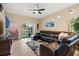 Relaxing living area featuring a leather sectional sofa, ceiling fan, and sliding glass doors at 10942 High Bush Ct, Orlando, FL 32825
