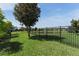 Spacious fenced in backyard with lush green lawn, mature trees, and a pond view at 13643 Budworth Cir, Orlando, FL 32832