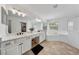 Bright bathroom features a double vanity, soaking tub and glass-enclosed shower at 13643 Budworth Cir, Orlando, FL 32832