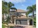 Beautiful two-story home with a well-manicured lawn and mature palm trees creating a tropical ambiance at 13643 Budworth Cir, Orlando, FL 32832