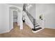 Bright foyer showcasing hardwood floors, a staircase with iron railings, and arched doorways leading to other rooms at 13643 Budworth Cir, Orlando, FL 32832