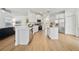 Bright, open kitchen with stainless steel appliances, white cabinets, island, and seamless transition to the living area at 13643 Budworth Cir, Orlando, FL 32832