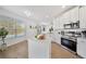 Well-lit kitchen with stainless steel appliances, white cabinetry, and an island overlooking the pool and outdoor area at 13643 Budworth Cir, Orlando, FL 32832