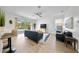 Bright living room with light wood floors, blue sofa, ceiling fan and sliding glass doors to the pool at 13643 Budworth Cir, Orlando, FL 32832