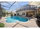 Beautiful kidney shaped screened in pool with brick paver deck and view of the covered patio at 13643 Budworth Cir, Orlando, FL 32832