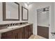 Bathroom showcasing double sinks with dark wood cabinets and a view into the bedroom at 142 Stone Hill Dr, Maitland, FL 32751