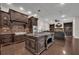 Gourmet kitchen featuring custom cabinetry, large island, and stainless steel appliances; adjacent to a cozy living area at 142 Stone Hill Dr, Maitland, FL 32751