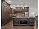 Gourmet kitchen with custom dark wood cabinets, a large granite island, and stainless steel appliances at 142 Stone Hill Dr, Maitland, FL 32751