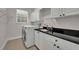 Bright laundry room featuring a washing machine, sink, and overhead cabinets at 142 Stone Hill Dr, Maitland, FL 32751