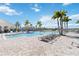 A spacious community pool featuring a large deck area with lounge chairs and a splash of palm trees at 14366 Lanikai Beach Dr, Orlando, FL 32827