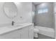 Modern bathroom featuring a single vanity, round mirror, and tiled shower/tub combo with natural light at 16904 Sw 30Th Avenue Rd, Ocala, FL 34473