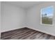 Empty bedroom featuring wood-look floors, fresh paint, white trim, and a window with green view at 16904 Sw 30Th Avenue Rd, Ocala, FL 34473