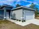 Detailed shot of the gray home exterior, featuring the two-car garage and manicured flower bed at 16904 Sw 30Th Avenue Rd, Ocala, FL 34473