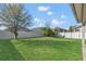 Spacious backyard with lush green grass surrounded by a white privacy fence at 1702 Reflection Ln, St Cloud, FL 34771