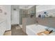 Bright bathroom featuring a separate glass-enclosed shower and soaking tub with gray tiling at 1702 Reflection Ln, St Cloud, FL 34771