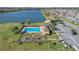 Aerial shot of a community pool, playground, and a scenic lake with manicured grounds at 1702 Reflection Ln, St Cloud, FL 34771
