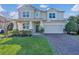 Charming two-story home boasts a brick driveway, manicured lawn, and inviting curb appeal at 1702 Reflection Ln, St Cloud, FL 34771