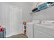 Functional laundry room with a white washer and dryer, shelving, and ample storage space at 1702 Reflection Ln, St Cloud, FL 34771