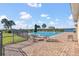Community pool with lounge chairs and umbrella-covered tables next to a lake at 1702 Reflection Ln, St Cloud, FL 34771