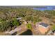 An aerial view of the property, featuring a pond, outbuildings, and surrounded by mature trees at 17220 Countrybrook Ln, Orlando, FL 32820