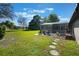 Expansive backyard with stone path leading to a screened-in pool and patio seating, perfect for relaxation at 17220 Countrybrook Ln, Orlando, FL 32820