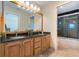 Bright bathroom with dual sinks, granite countertop, updated fixtures, and shower stall at 17220 Countrybrook Ln, Orlando, FL 32820