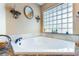 Corner bathtub with tile surround, accompanied by tasteful decor in this well-lit bathroom at 17220 Countrybrook Ln, Orlando, FL 32820