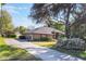 Exterior view of a house with mature trees, a green lawn, and established landscaping at 17220 Countrybrook Ln, Orlando, FL 32820