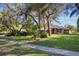 Charming house with mature trees, green lawn, and concrete sidewalk at 17220 Countrybrook Ln, Orlando, FL 32820