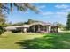 Lovely home with a manicured lawn, mature trees, and colorful flower beds at 17220 Countrybrook Ln, Orlando, FL 32820