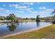Scenic view of a tranquil pond, reflecting clear blue skies, and lush green surroundings at 17220 Countrybrook Ln, Orlando, FL 32820