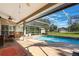 A covered outdoor pool with a dining table on the patio offers a space for relaxation and outdoor meals at 17220 Countrybrook Ln, Orlando, FL 32820
