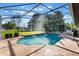 A private in-ground pool is surrounded by a screened enclosure, offering a serene retreat with clear blue skies at 17220 Countrybrook Ln, Orlando, FL 32820