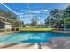 Sparkling pool with a screened enclosure and lush green surroundings at 17220 Countrybrook Ln, Orlando, FL 32820