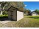 A well-maintained storage shed sits in a grassy yard near the detached garage, offering ample storage space at 17220 Countrybrook Ln, Orlando, FL 32820