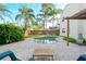 Backyard pool with a paver patio, lush landscaping, and a pergola with an outdoor seating area in a tropical setting at 1751 Meadowgold Ln, Winter Park, FL 32792