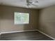 Neutral bedroom showcasing natural light, a modern ceiling fan, and gray plank flooring at 178 Chippendale Ter, Oviedo, FL 32765