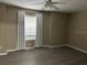 Serene bedroom featuring neutral walls, gray plank flooring, and a bright window with curtains at 178 Chippendale Ter, Oviedo, FL 32765