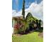 Landscaped backyard featuring lush greenery, mulch beds, and manicured lawn at 1923 Willow Wood Dr, Kissimmee, FL 34746