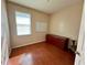 Cozy bedroom featuring light-filled window, wood floor, cabinet and desk chair at 1923 Willow Wood Dr, Kissimmee, FL 34746