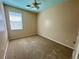 This bedroom has carpet flooring, a ceiling fan, and a window that lets in natural light at 1923 Willow Wood Dr, Kissimmee, FL 34746