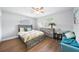 Cozy bedroom featuring a ceiling fan, hardwood floors, a dresser, and modern furniture at 2311 Ashland Blvd, Orlando, FL 32808