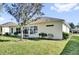 Exterior view of the house showcasing the backyard, patio, and lush green lawn at 24515 Bocage Way, Leesburg, FL 34748