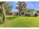Expansive backyard with lush green lawn and mature trees, offering privacy and space for outdoor activities at 24515 Bocage Way, Leesburg, FL 34748
