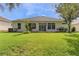 Well-maintained backyard featuring a lush green lawn and a home with large windows and sliding glass doors at 24515 Bocage Way, Leesburg, FL 34748