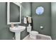 Stylish powder room features a pedestal sink, neutral tile floor, and charming octagonal window at 24515 Bocage Way, Leesburg, FL 34748
