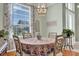 Bright dining room featuring a large window, elegant light fixture, and seating for four at 24515 Bocage Way, Leesburg, FL 34748